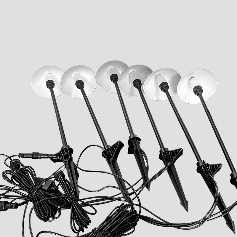 Six slim black garden light stakes with translucent round shades and connecting cables