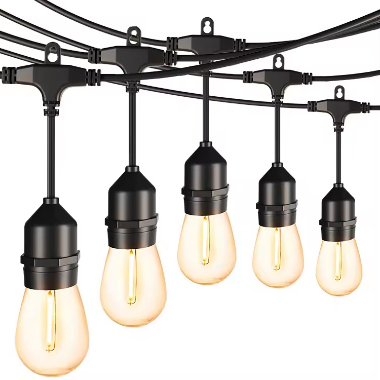 Five illuminated bulbs on short drop cables below black string-light cable and hanging loops